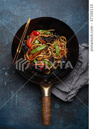 Asian stir fry noodles with vegetables in black wok pan Asian stir fry noodles with vegetables in black wok pan 87388110