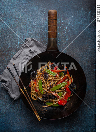 Asian stir fry noodles with vegetables in black wok pan Asian stir fry noodles with vegetables in black wok pan 87388111