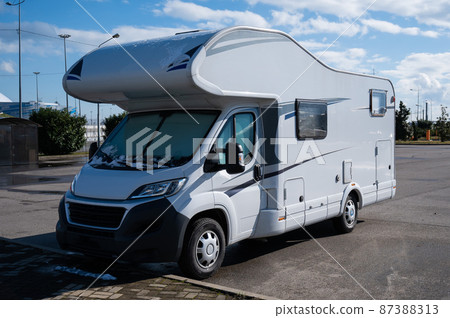 White house on wheels in the parking lot. 87388313