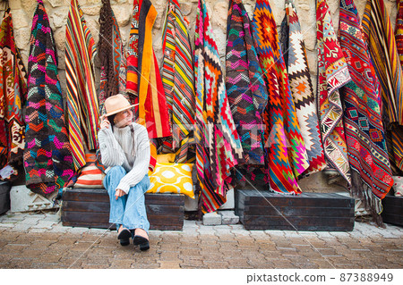 Old traditional Turkish carpet shop in cave house Cappadocia, Turkey Kapadokya. Young woman on vacation in Turkey 87388949