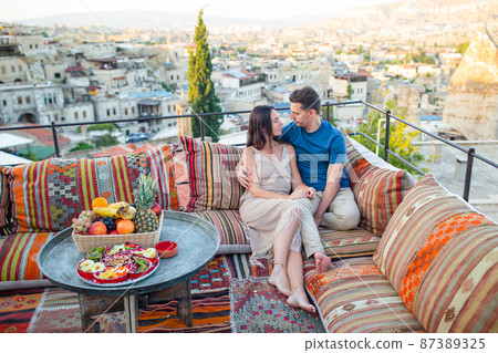 Happy young couple during sunrise watching hot air balloons in Cappadocia, Turkey 87389325