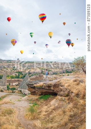 Happy young man watching hot air balloons in Cappadocia, Turkey Happy young man watching hot air balloons in Cappadocia, Turkey 87389328
