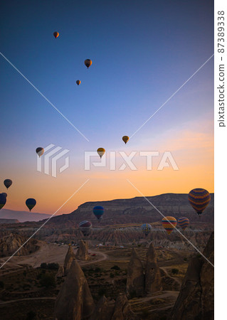 GOREME, TURKEY - SEPTEMBER 18. 2021: Bright hot air balloons in sky of Cappadocia, Turkey GOREME, TURKEY - SEPTEMBER 18. 2021: Bright hot air balloons in sky of Cappadocia, Turkey 87389338