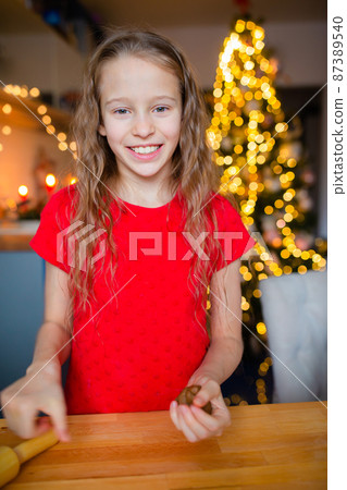 Adorable little girl baking Christmas gingerbread cookies 87389540