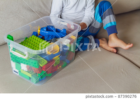Child playing with toy blocks sitting on sofa 87390276
