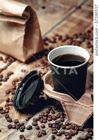 take away coffee cup and coffee beans on wooden background take away coffee cup and coffee beans on wooden background 87390337