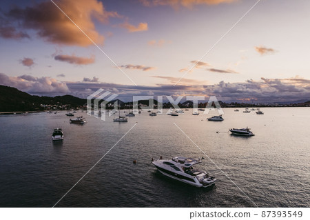 Many moored yachts off the coast at sunset. Many moored yachts off the coast at sunset. 87393549