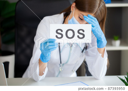 The doctor holds a form with the text sos 87393950
