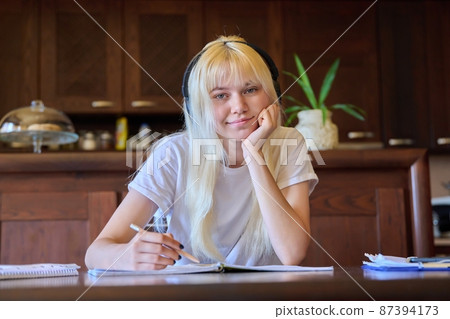Portrait of a teenage girl student in headphones studying at home Portrait of a teenage girl student in headphones studying at home 87394173
