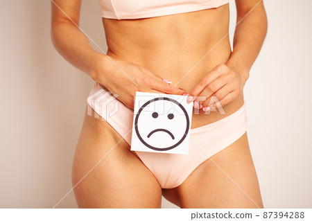 Female Body Holding Sad Smiley Card Near Stomach Female Body Holding Sad Smiley Card Near Stomach 87394288