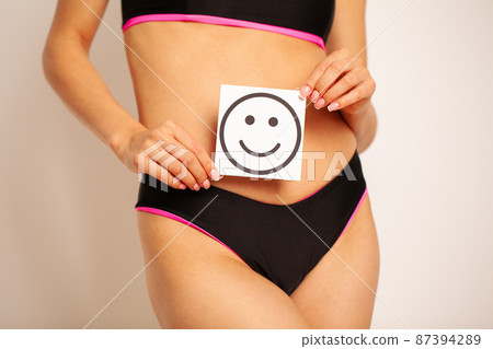 Closeup Of Healthy Female With Beautiful Fit Slim Body Holding Card With Happy Smiley Closeup Of Healthy Female With Beautiful Fit Slim Body Holding Card With Happy Smiley 87394289