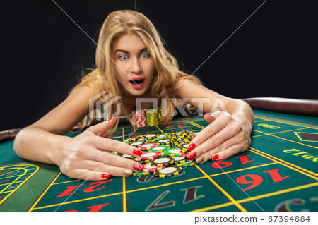 Young pretty women playing roulette wins at the casino 87394884