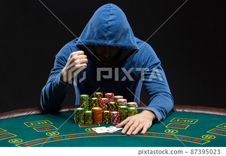 Portrait of a professional poker player sitting at pokers table 87395023