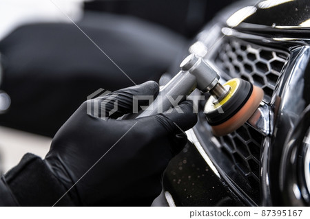 Car detailing technician polishing chrome shine decor on car 87395167