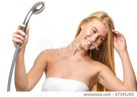 Young woman in a towel holding shower head Young woman in a towel holding shower head 87395269