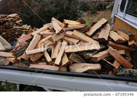 Freshly cracked oak firewood packed in a light tiger carrier Freshly cracked oak firewood packed in a light tiger carrier 87395346
