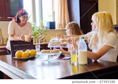 Children two sisters eating at home in the kitchen 87395386
