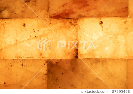 Salt bricks close up. Illuminated salt bricks in the sauna, background, texture Salt bricks close up. Illuminated salt bricks in the sauna, background, texture 87395498