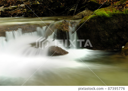 Long exposure view of a hidden river in Crimea, Ukraine. A stone set against a blurred water pattern is ideal for background use. 87395776