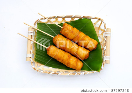 Fried dough snacks wrapped sausage in bamboo basket 87397248