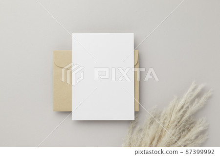 Blank greeting card invitation Mockup 5x7 on Brown envelope with dried flowers on beige background, flat lay, mockup 87399992