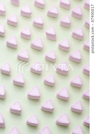 Valentine's Day candy hearts marshmallows over green pastel background 87400817