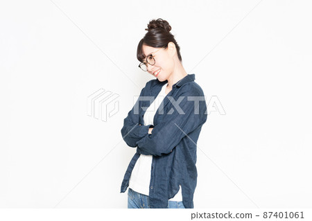 戴眼鏡的女人站在白色背景前,雙臂交叉 戴眼鏡的女人站在白色背景前,雙臂交叉 87401061