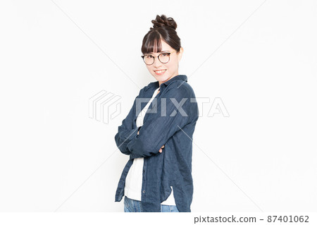 戴眼鏡的女人站在白色背景前,雙臂交叉 戴眼鏡的女人站在白色背景前,雙臂交叉 87401062