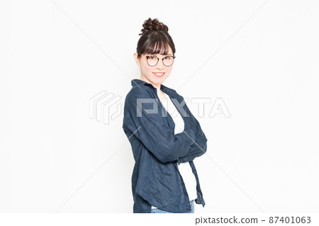 戴眼鏡的女人站在白色背景前,雙臂交叉 戴眼鏡的女人站在白色背景前,雙臂交叉 87401063