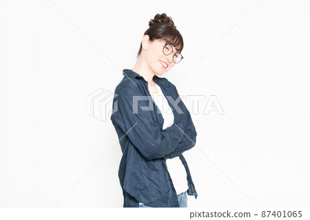 戴眼鏡的女人站在白色背景前,雙臂交叉 戴眼鏡的女人站在白色背景前,雙臂交叉 87401065
