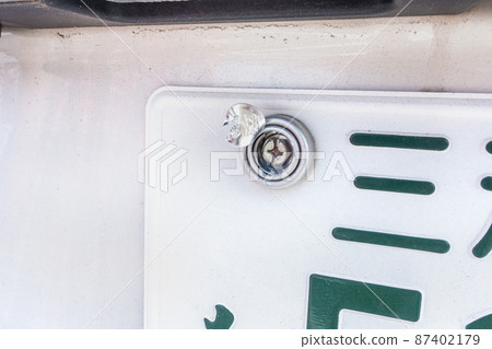 A photo of the car license plate being unsealed. Image of license plate reissue. A photo of the car license plate being unsealed. Image of license plate reissue. 87402179