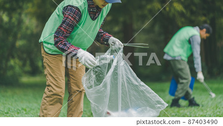 Volunteer picking up trash 87403490