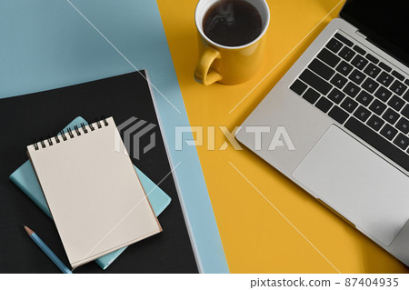 Top view notepad, computer laptop and coffee cup on colorful background. 87404935