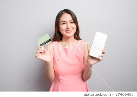Charming asian woman hand holding smartphone and show credit card. Presenting your product. Charming asian woman hand holding smartphone and show credit card. Presenting your product. 87406495