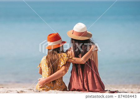 Beautiful mother and daughter at the beach enjoying summer vacation Beautiful mother and daughter at the beach enjoying summer vacation 87408443