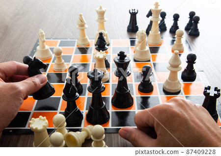 Hand moving a chess piece Hand moving a chess piece 87409228