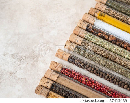 Various dry spices in glass tubes on textured background. Various dry spices in glass tubes on textured background. 87413489