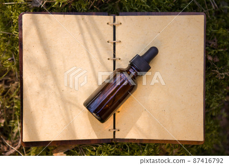 Bottles of essential oils, medicinal herbs, old book. View from above. 87416792