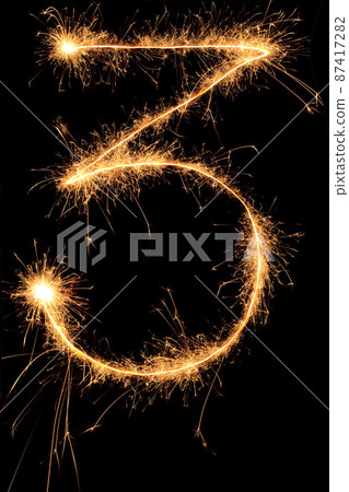 Burning Sparkling number 0 zero isolated on black background. Beautiful Glowing design element for greeting card, holiday flyer. 87417282