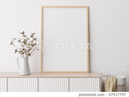 Empty vertical picture frame on white wall in modern living room. Mock up interior in minimalist, scandinavian style. Free space for picture. Console, rattan basket, cotton plant in vase. 3D rendering Empty vertical picture frame on white wall in modern living room. Mock up interior in minimalist, scandinavian style. Free space for picture. Console, rattan basket, cotton plant in vase. 3D rendering 87417747