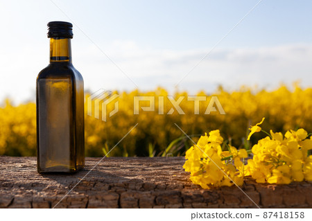Oil bottle on the background of oilseed rape.  87418158