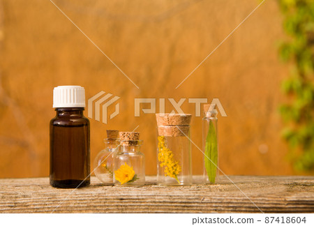 Bottle of essential oil with herbs, flowers. BACH Bottle of essential oil with herbs, flowers. BACH 87418604
