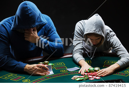 Poker players sitting at poker table and going all-in 87419415