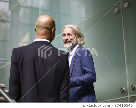 two corporate executives talking while ascending stairs two corporate executives talking while ascending stairs 87419546