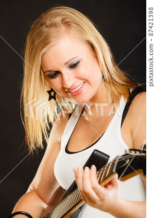 Woman playing on electric guitar and singing 87421398