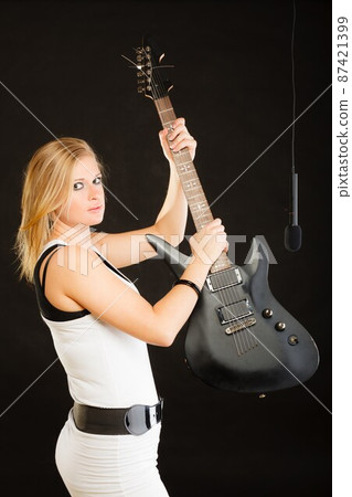 Woman playing on electric guitar and singing 87421399