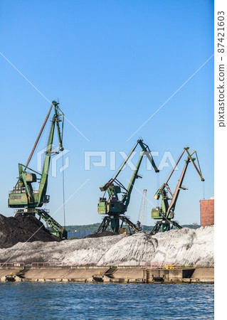 Cranes in morning harbour. 87421603
