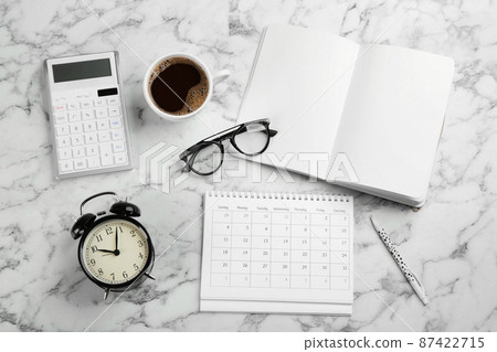 Flat lay composition with calendar and cup of coffee on white marble table 87422715