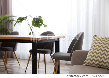 Fresh leaves of tropical plants on table in room. Home decoration 87422786