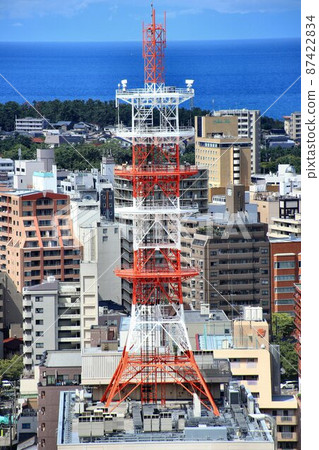 A radio tower for communication with a steel truss structure that rises in the city 87422834